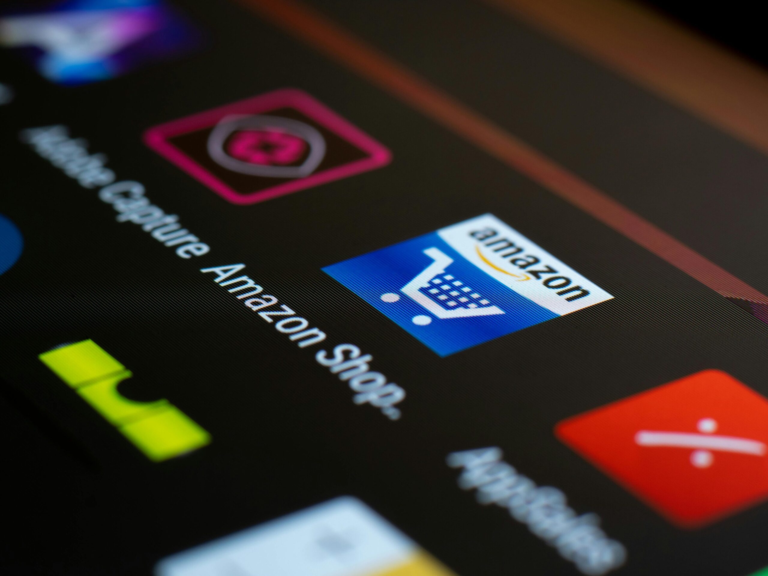 Close-up of the Amazon shopping app icon on a smartphone screen. Ideal for online shopping and technology themes.